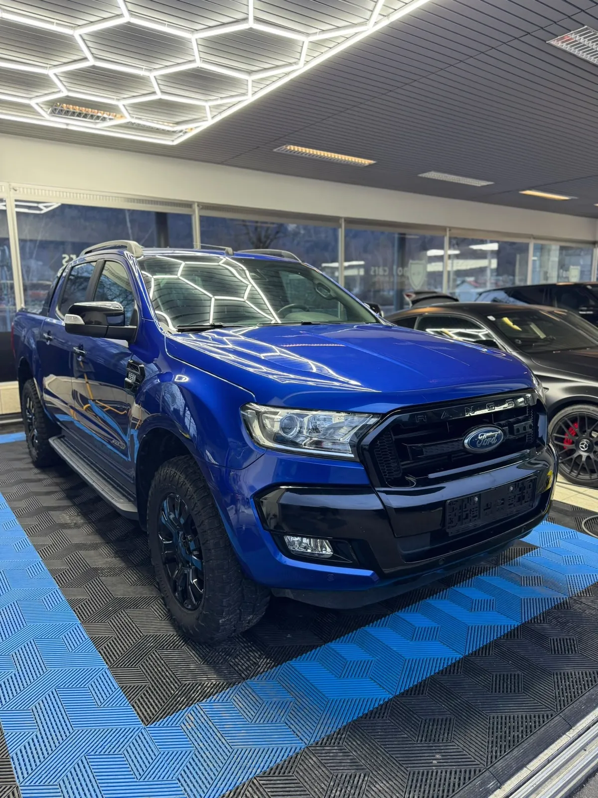 Ford Ranger in der Halle von Saff Car Lounge in Kufstein nach der Aufbereitung, Hexagon-Leuchten spiegeln sich im Lack