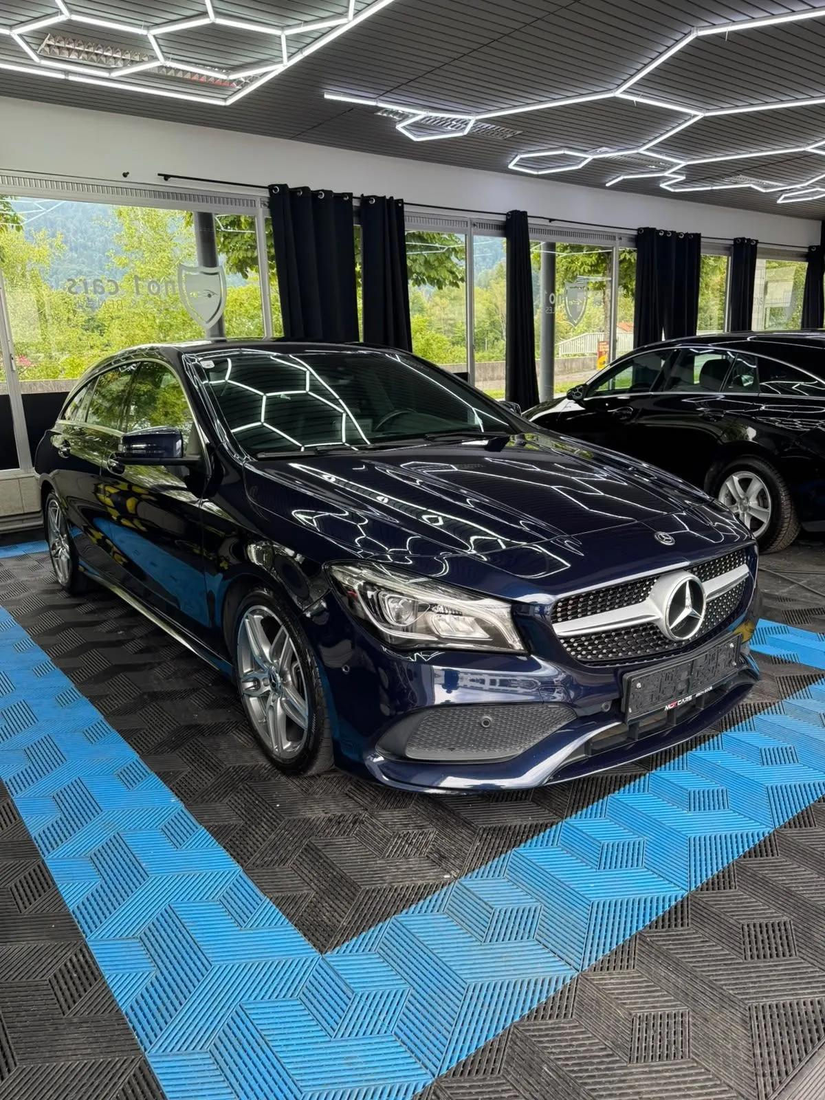 Mercedes CLA Shooting Brake in der Halle von Saff Car Lounge in Kufstein nach der Aufbereitung, Hexagon-Leuchten spiegeln sich im Lack