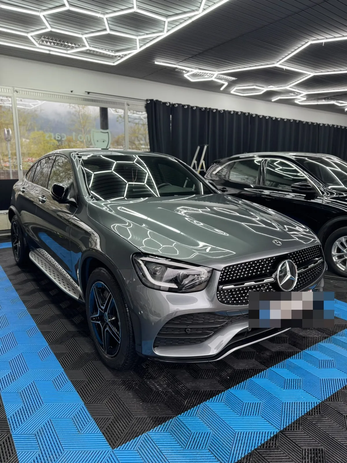 Mercedes GLC in der Halle von Saff Car Lounge in Kufstein nach der Aufbereitung, Hexagon-Leuchten spiegeln sich im Lack